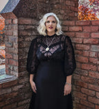 silver haired model wearing sheer black lace blouse with spider webs