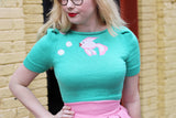 model wearing teal knitted sweater with a pink fish and bubbles